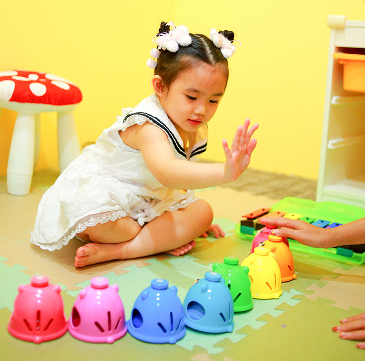 Toddler exploring rhythm and percussion with a music teacher