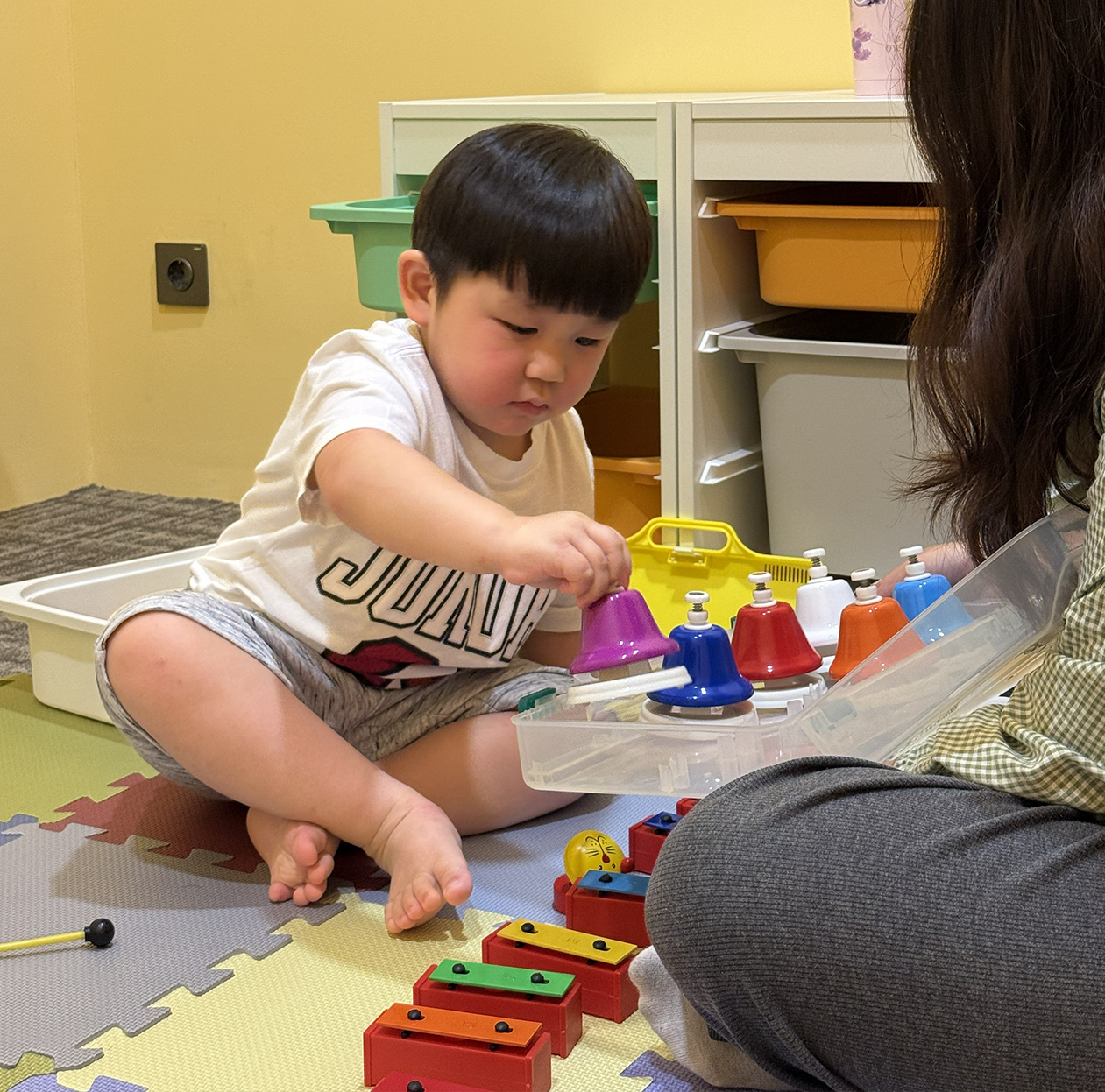 Young child exploring a melodic instrument during Music Adventure